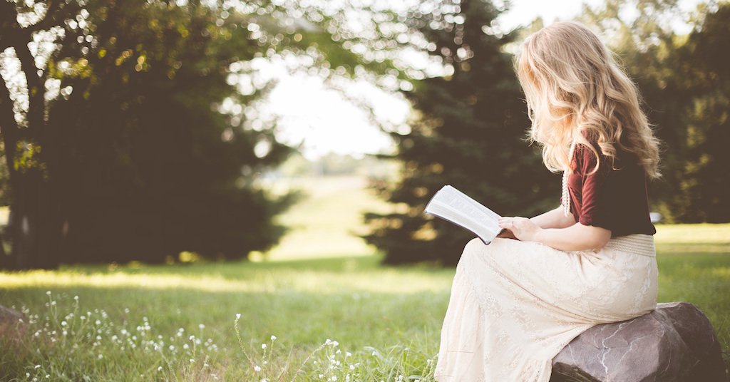 Woman sitting outside reading a book