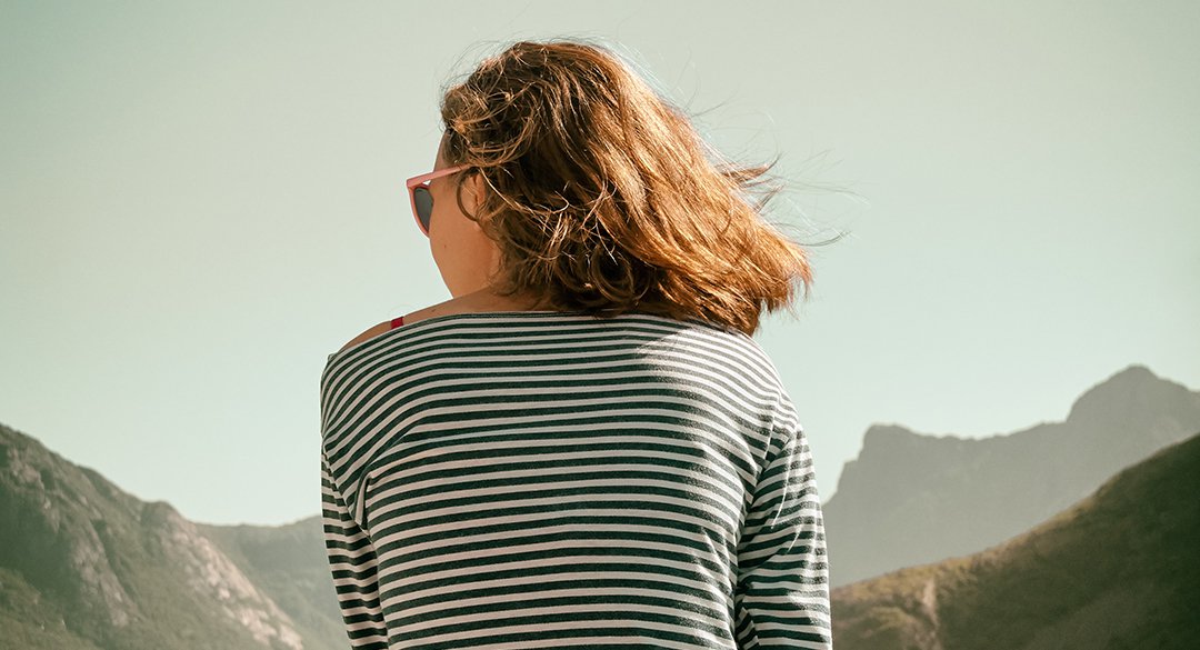 Woman sitting on mountain looking to the left