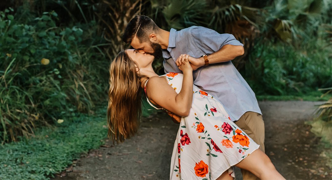 Man kissing woman and holding hand