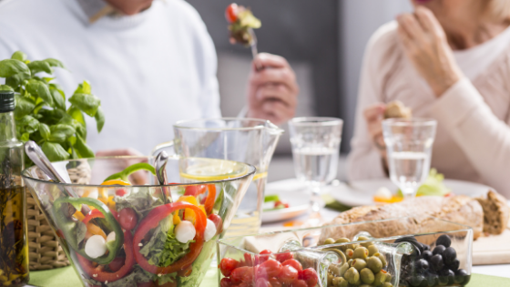 A couple is seen eating a healthy meal of salad, olives and more-5.png
