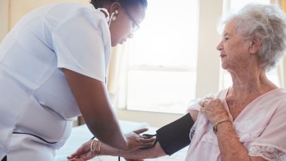 A female caregiver is seen checking the blood pressure of a senior woman-3.jpeg