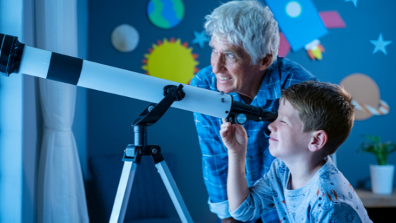 A grandpa and grandson use a telescope to look at the stars from the grandson's bedroom-3.png