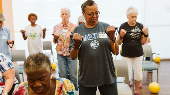 A group of older women are seen working out with resistance bands - 1.png