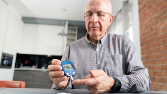 A man is seen testing his blood sugar levels in his kitchen - 2.jpeg