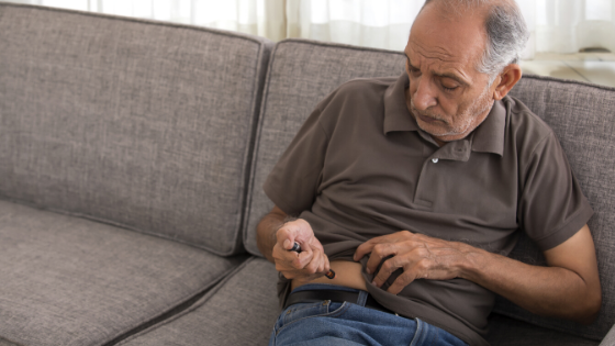 A man sits on his couch while injecting his insulin-2.png