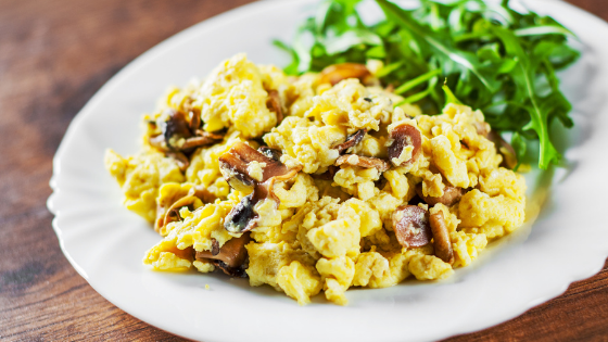 A plat of scrambled eggs with mushrooms and arugula-3.png