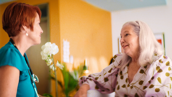 A provider and a female patient speak casually in the lobby of an Iora with One Medical office-4.png