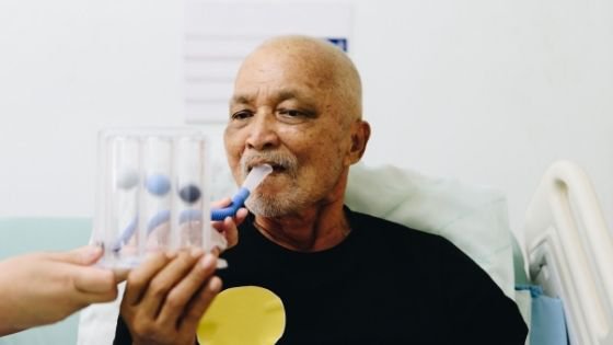 A senior black man is seen blowing into an incentive spirometer-6.jpeg