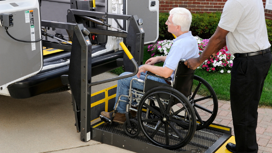 A senior man in a wheelchair is lighted into a handicap-accessible van-9.png