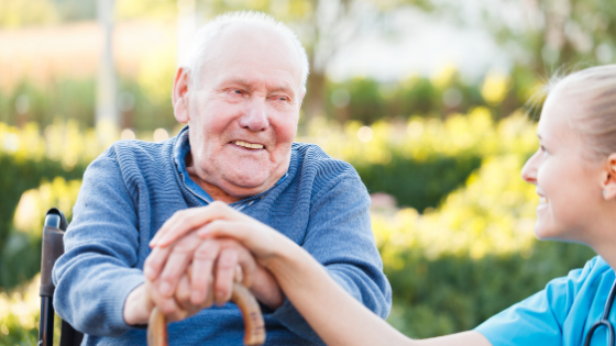 A senior man in a wheelchair smiles at his home health aide-1.png