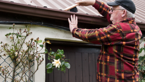 A senior man is seen cleaning his gutters-4.png