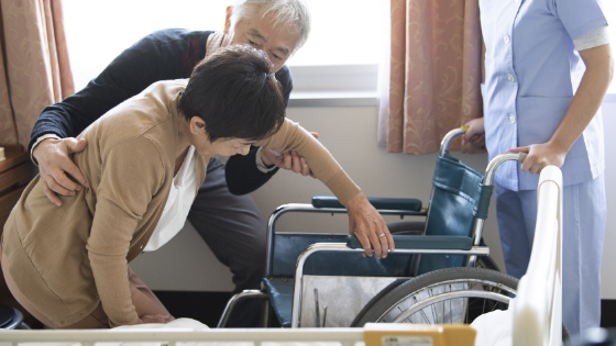 A senior man is seen helping his elderly wife into her wheelchair-5.png