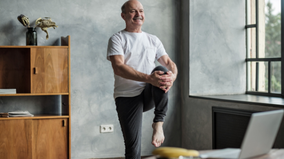 A senior man is seen holding his knee into his chest balancing on one leg-4.png