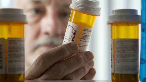 A senior man reaches into his medicine cabinet for his prescription-3.png