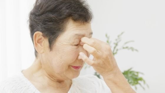 A senior woman pinches her forehead in pain- 3.jpeg