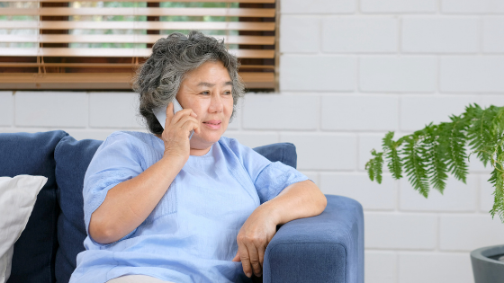 A senior woman sits on the couch while talking on the phone-6.png