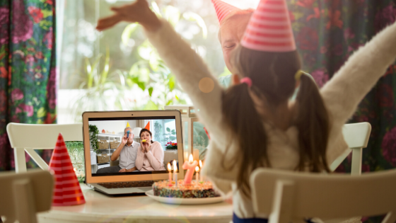 A young girl celebrates her birthday with a cake while video chatting with grandparents from afar-2.png