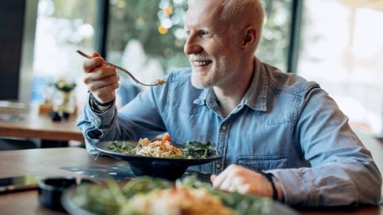 A young senior man smiles while eating a healthy meal-1.jpeg