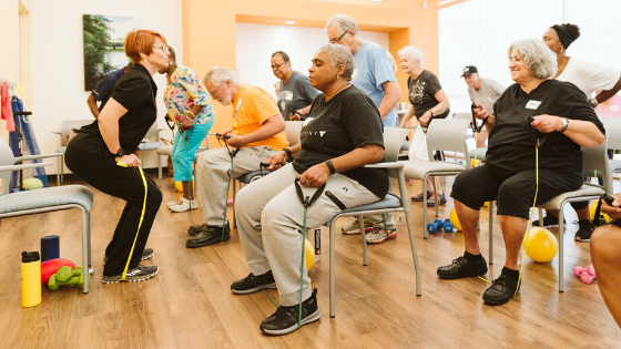An Iora Primary Care instructor demonstrates leg strength exercises to a class of older adults - 3.png