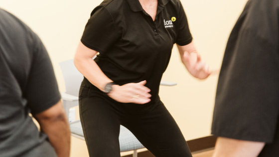 An Iora Primary Care team member demonstrates a sit stand exercise-1.png