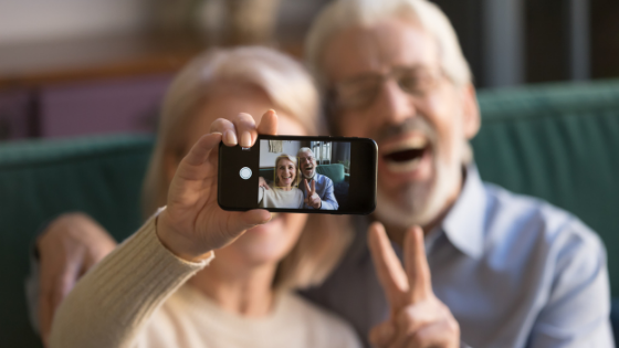 An elderly couple are seen taking a selfie signing the peace sign-2.png