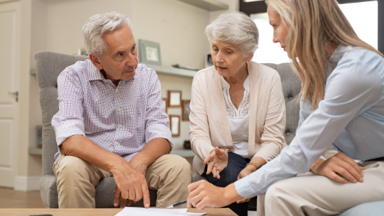 An elderly couple looks over paperwork with a health consultant-5.png