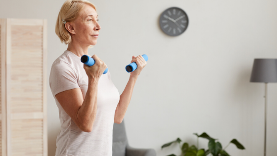 An older woman holds hand weights in her living room-3.png