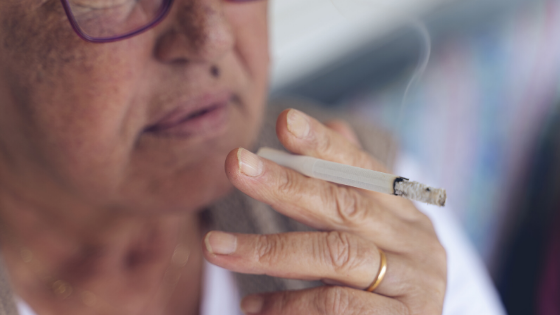 Close up of an older woman with glasses smoking a cigarette-3.png