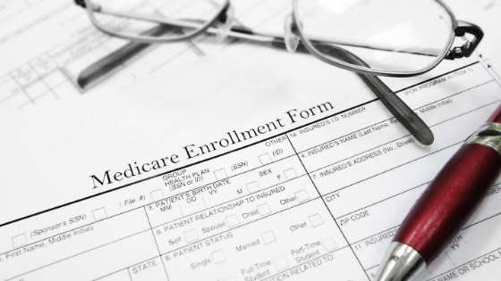 Medicare Enrollment forms with a pen and glasses-4.png
