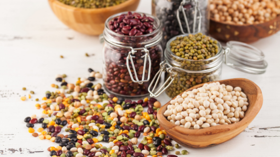 Multiple types and colors of beans and lentils spill out of jars and bowls-7.png