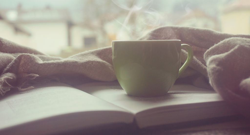 Steaming coffee cup on book