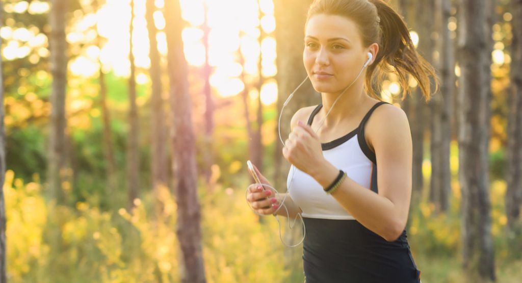 Young woman running with phone