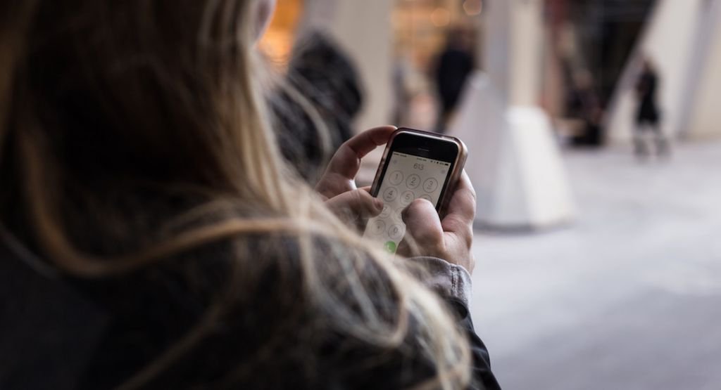 Woman entering her password into her phone