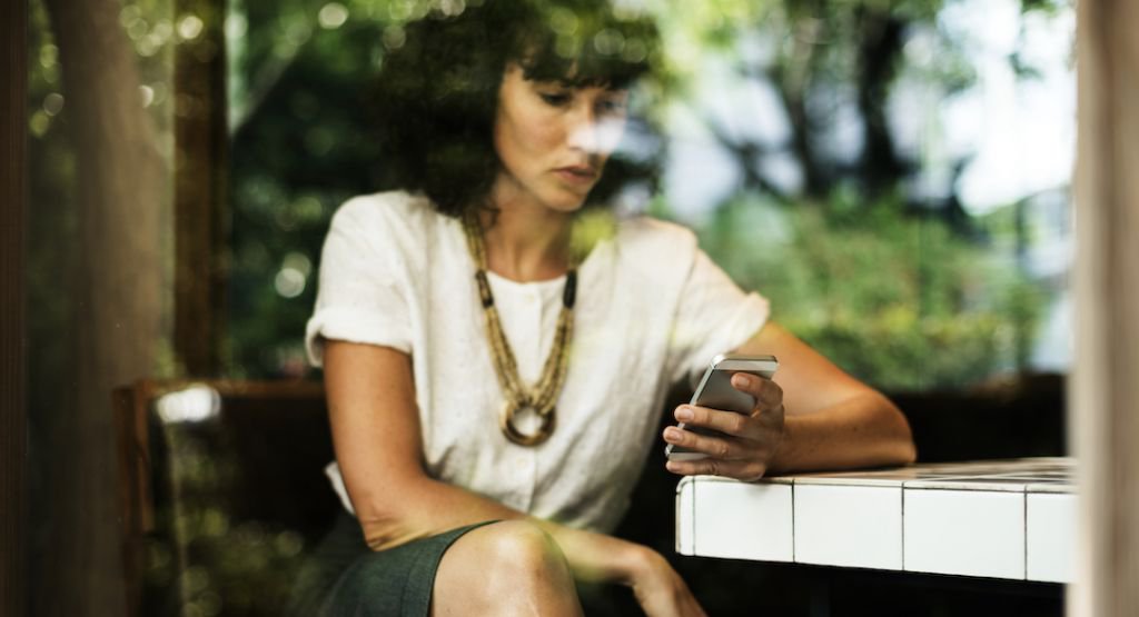 Woman holding and looking at mobile device