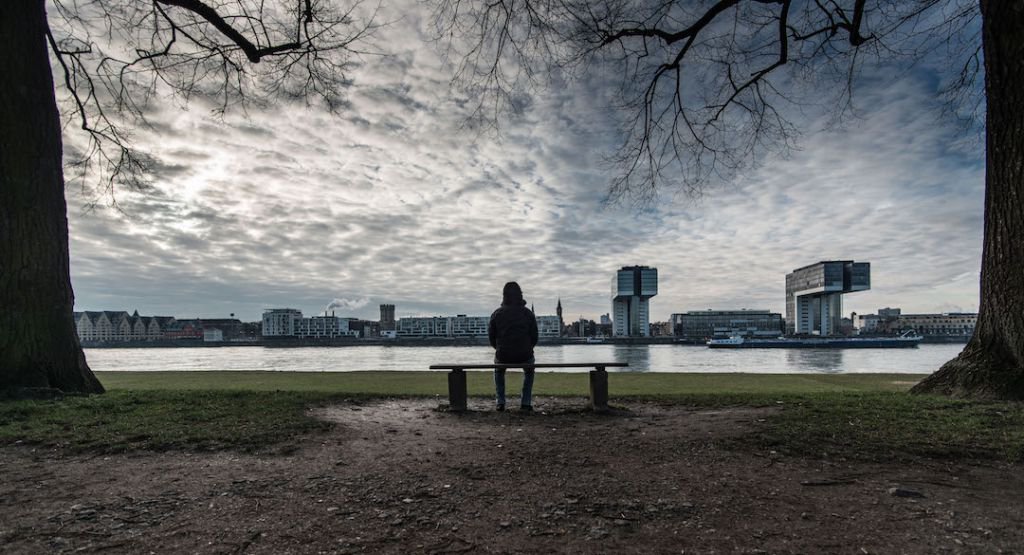 Person sitting on a park bench overlooking body of water