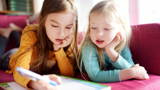 Two young girls are seen writing a letter on the couch-4.png