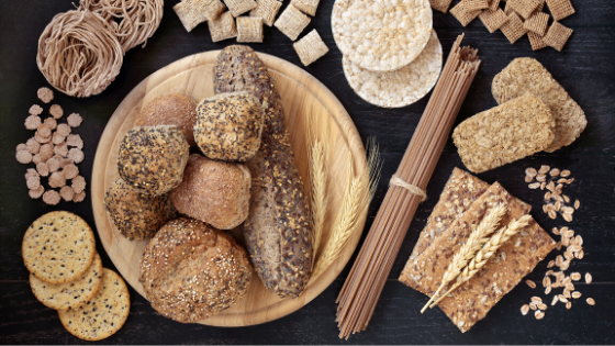 Whole grain breads, pasta and assorted crackers are laid out on a table-3.png