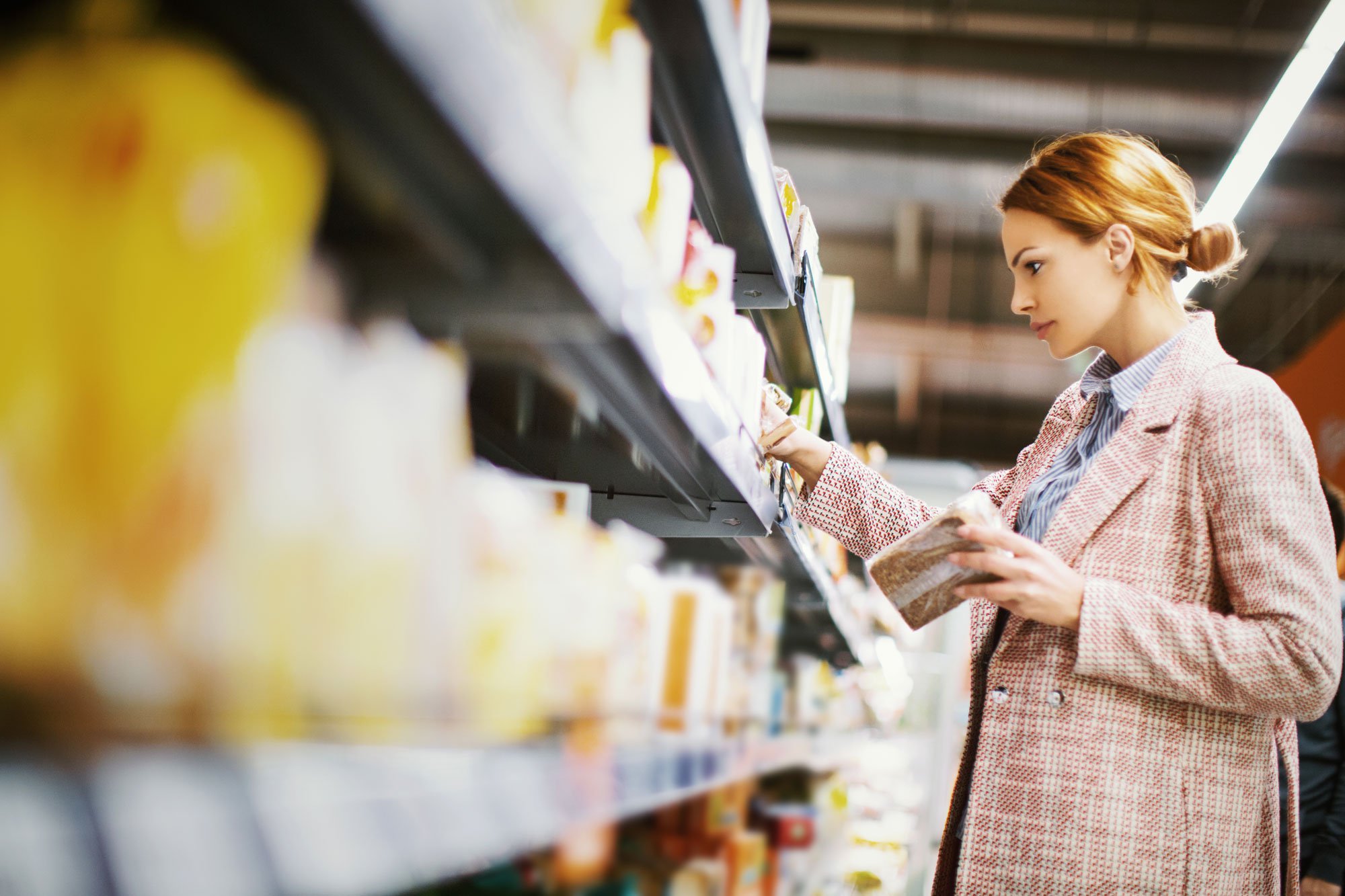 Woman buying gluten free bread in grocery store