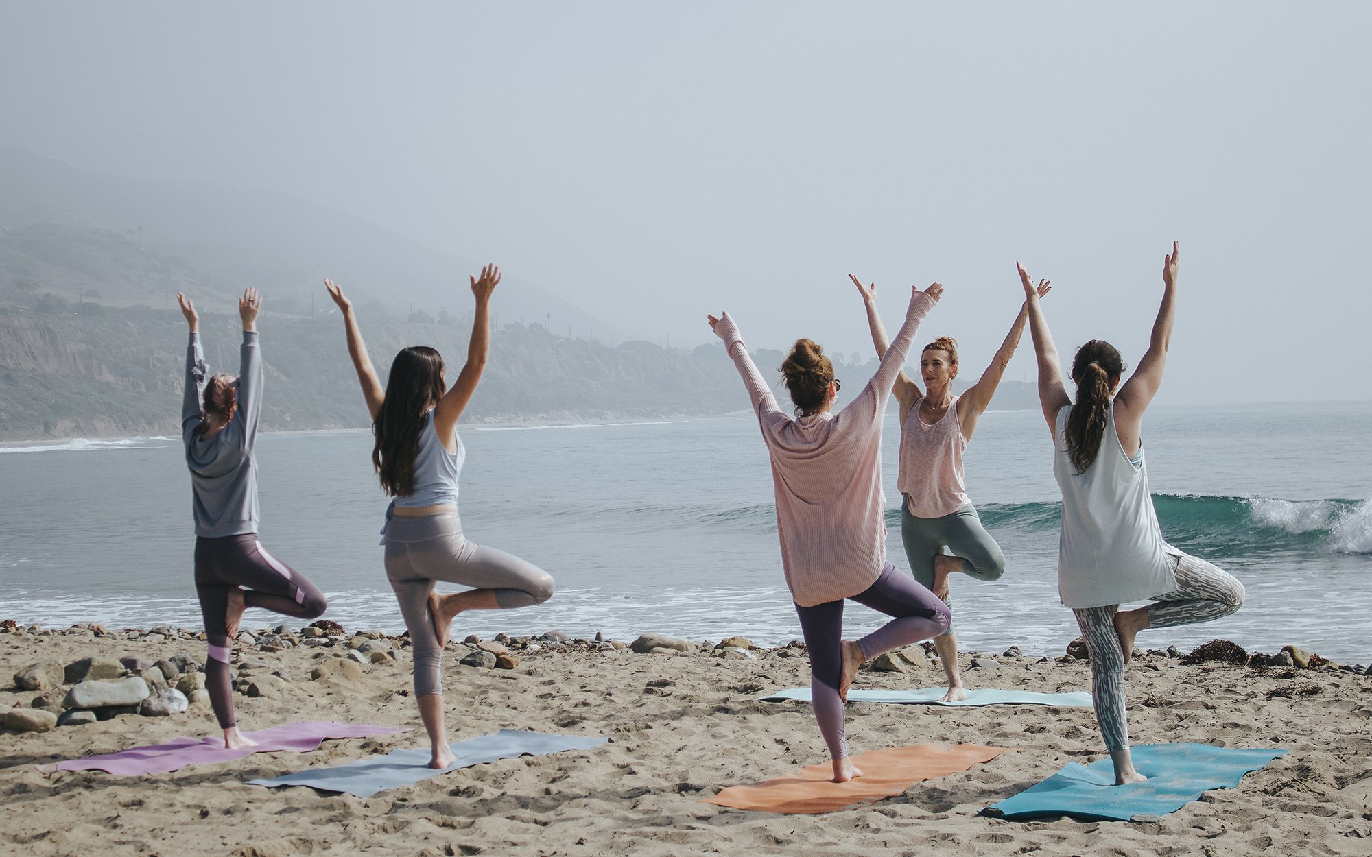 Women doing yoga on the beach