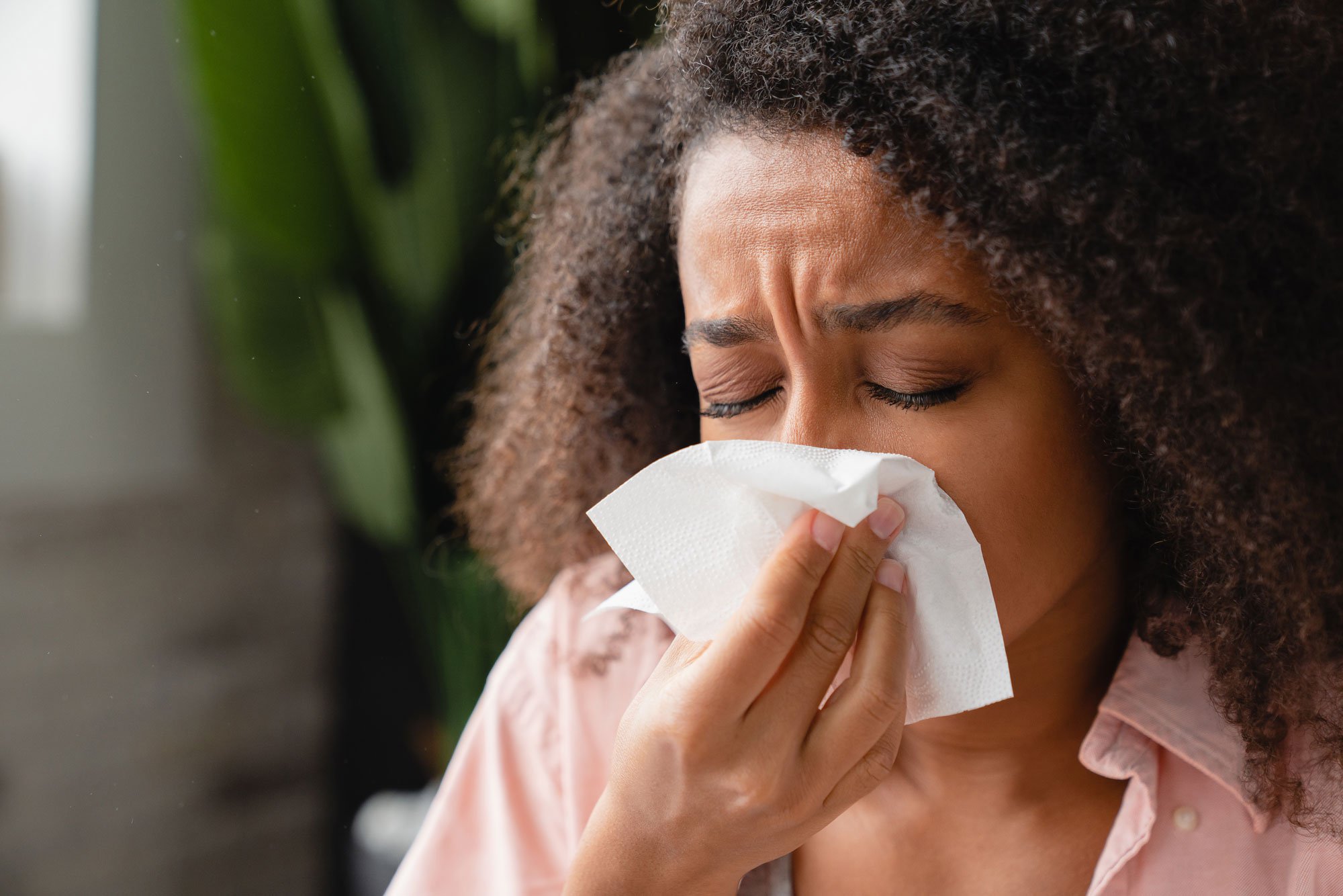 Woman blowing her nose into tissue