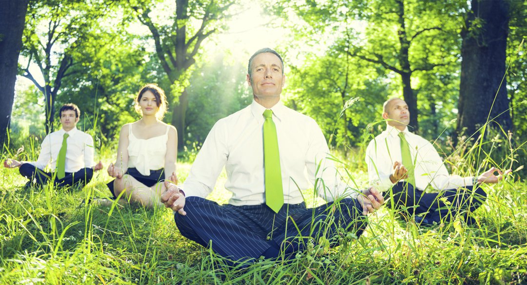 Four people sitting in the forest in a yoga pose