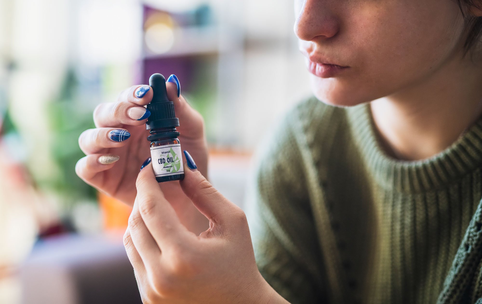 Woman holding CBD oil drops