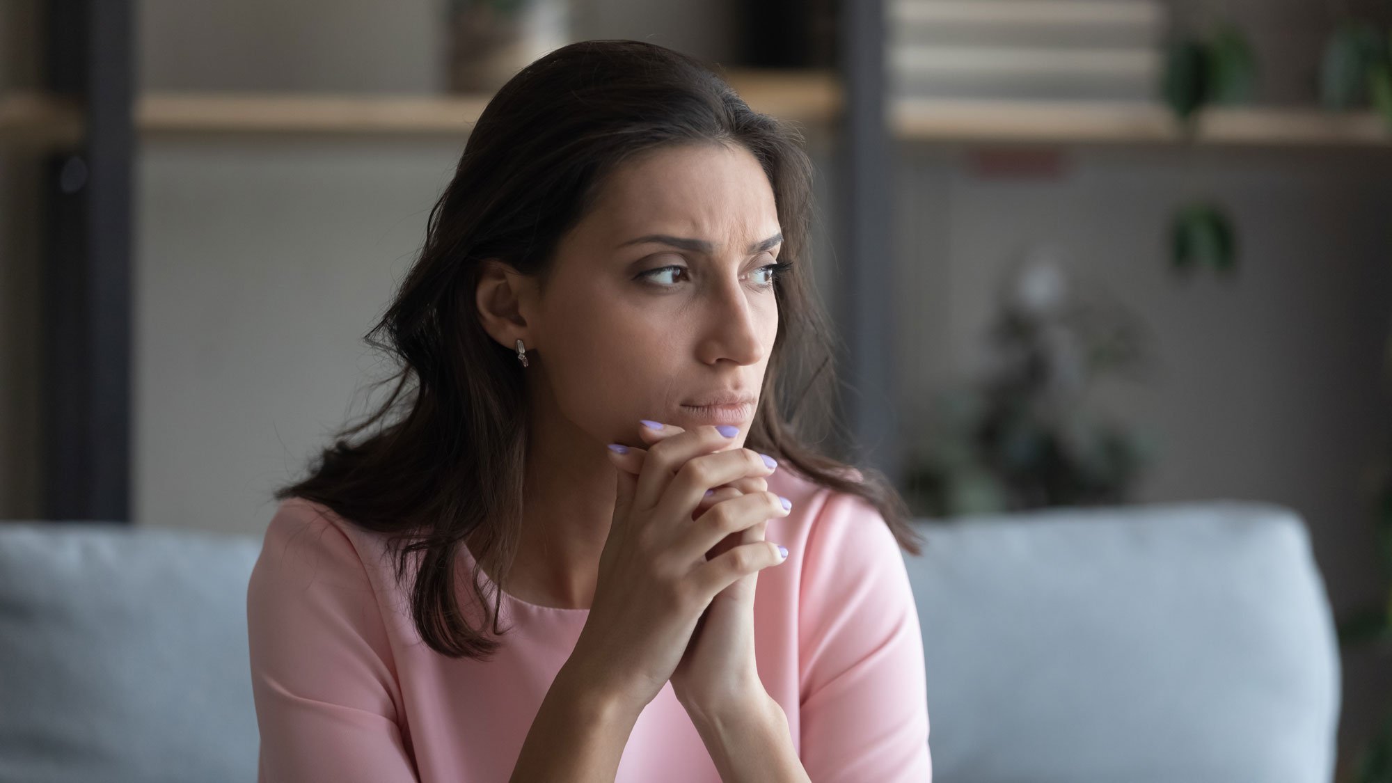 Woman sitting on couch looking worried