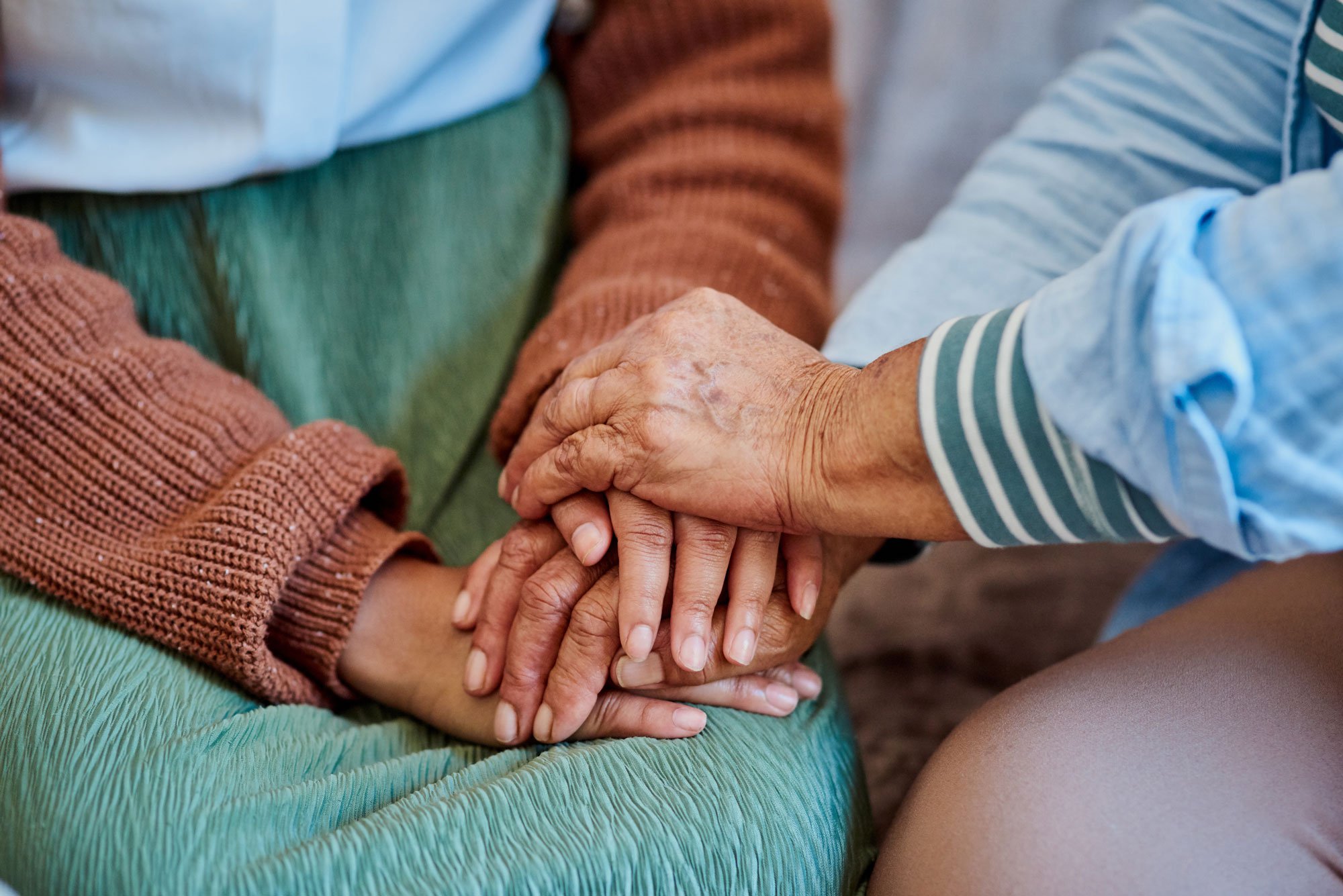 Photo of two people holding hands on sofa