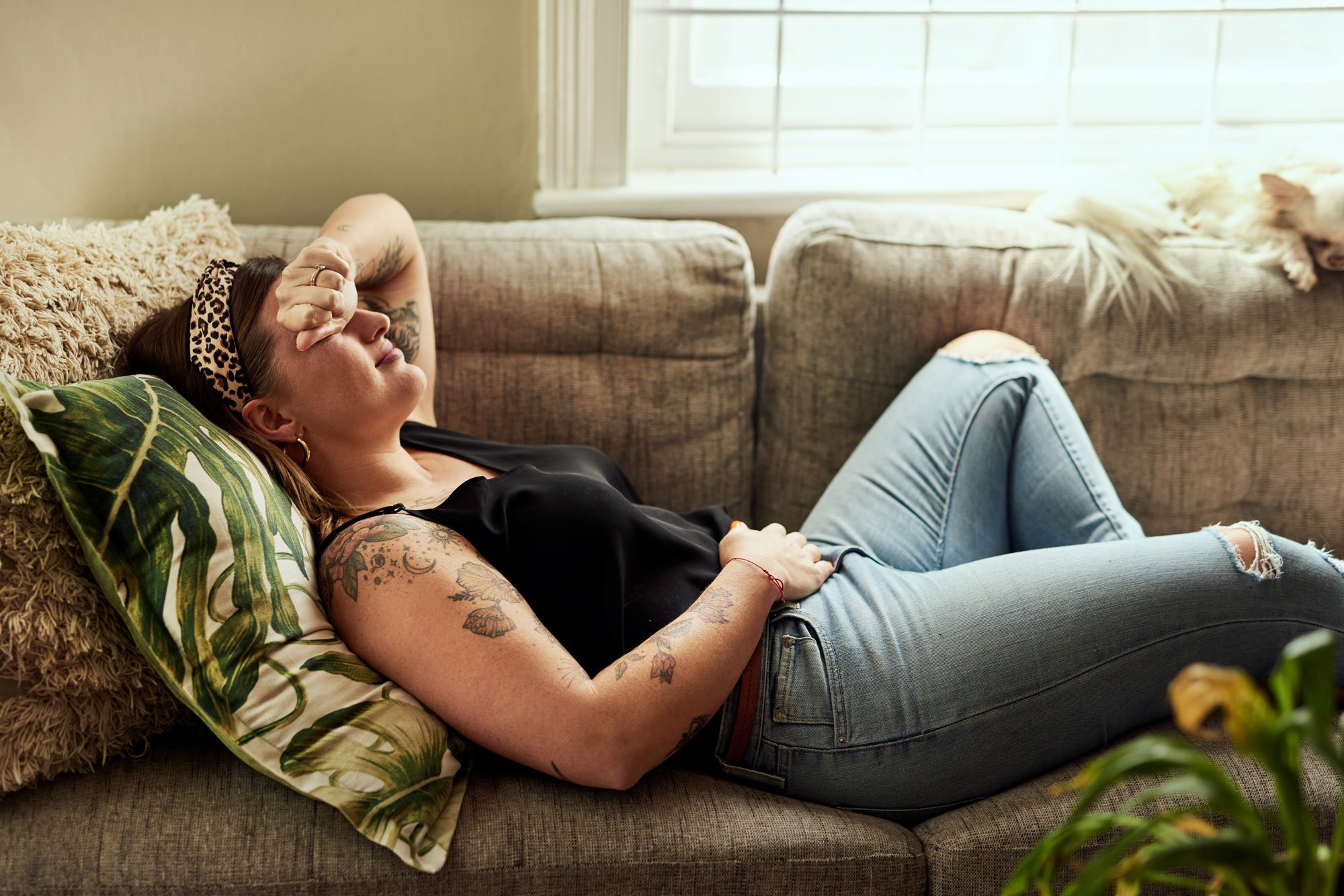 Woman laying on couch holding stomach
