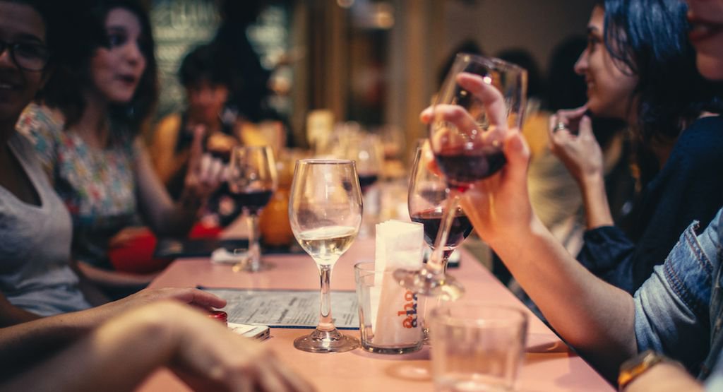 Woman drinking wine at a table