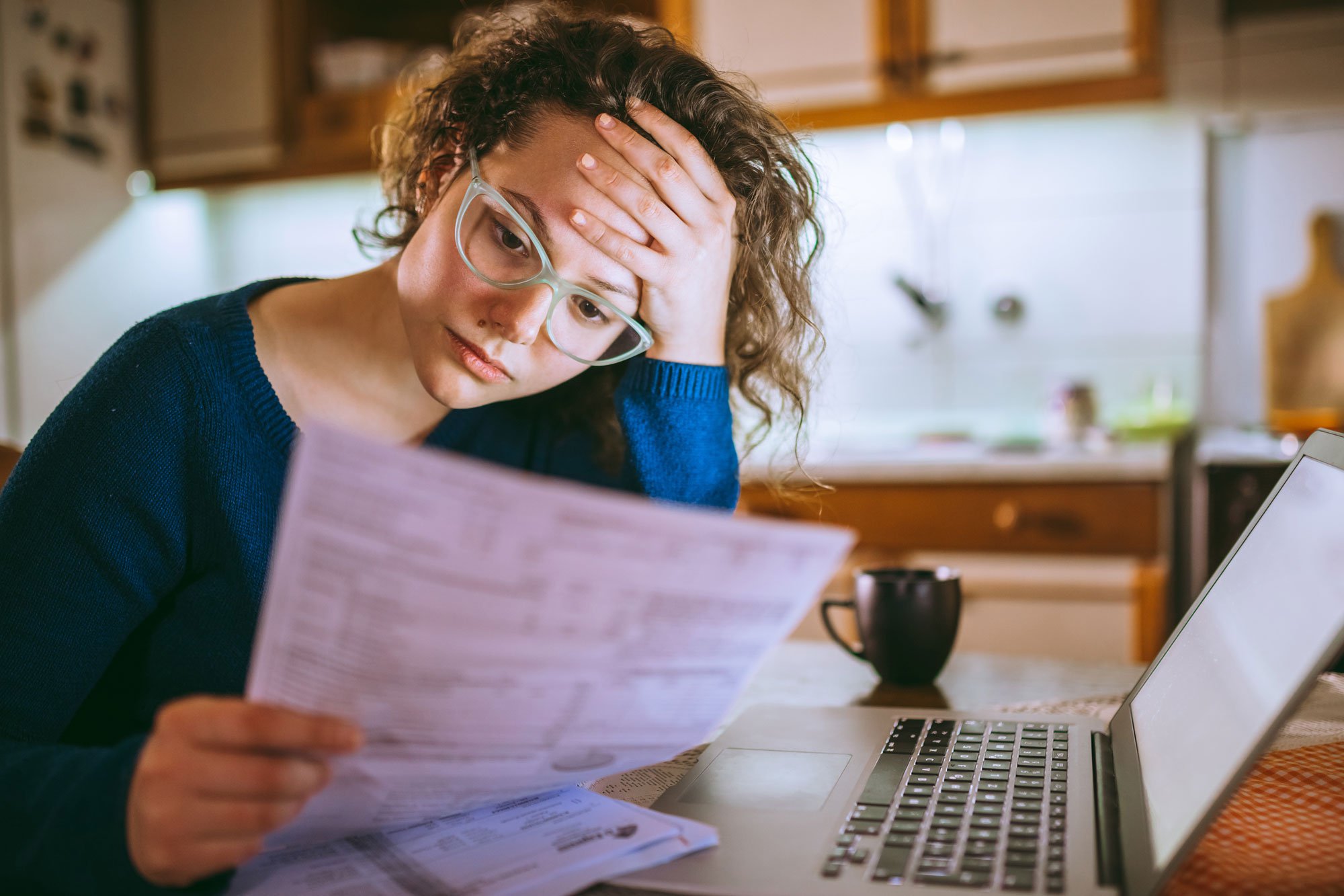 Women looking stressed while reading over bills