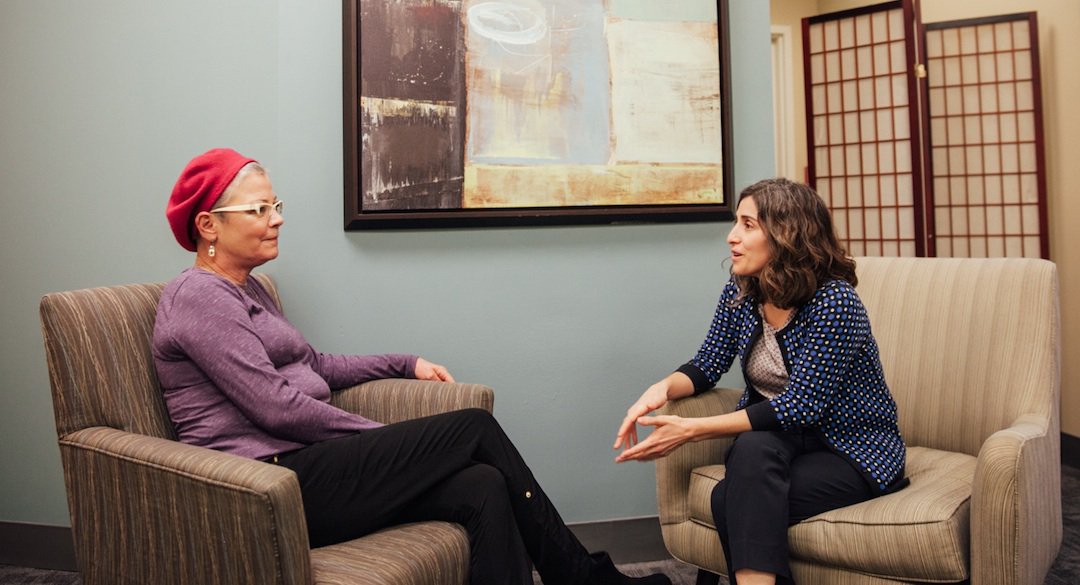 Two woman sitting in chairs and talking