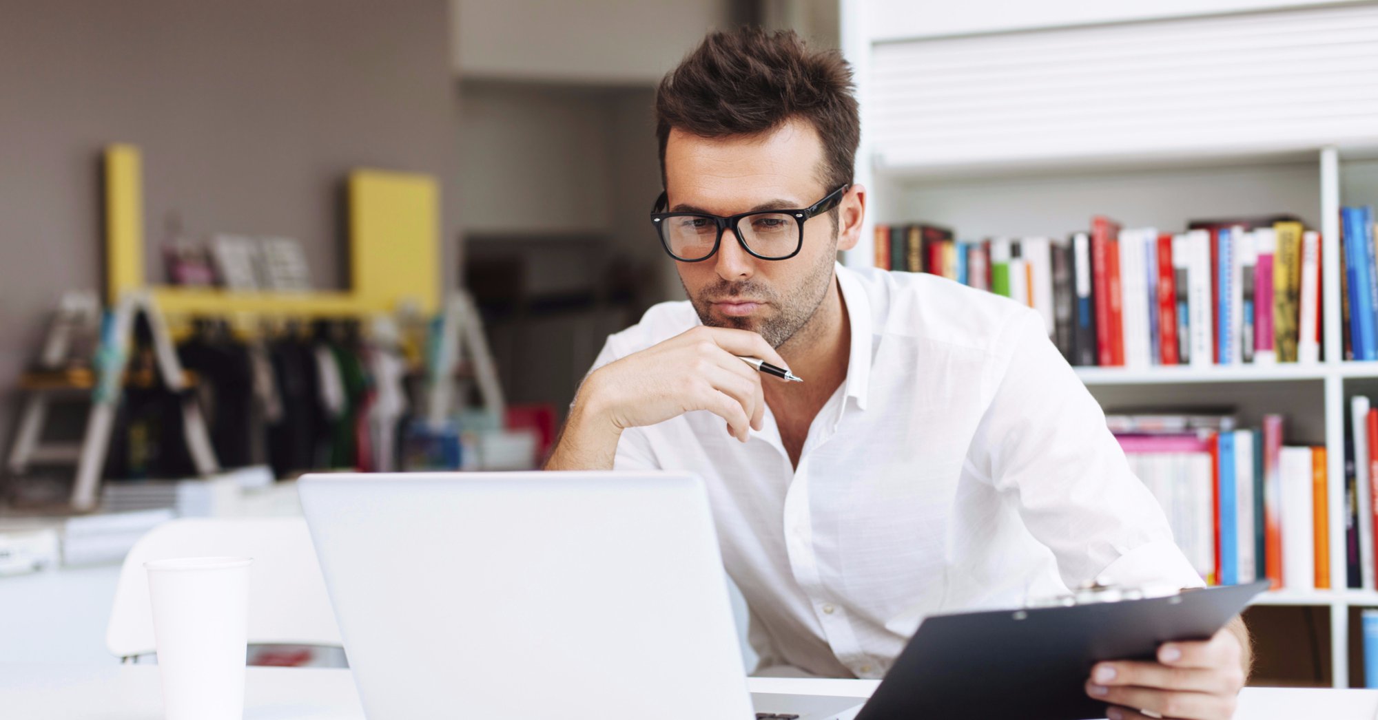 Man holding clipboard and looking at computer