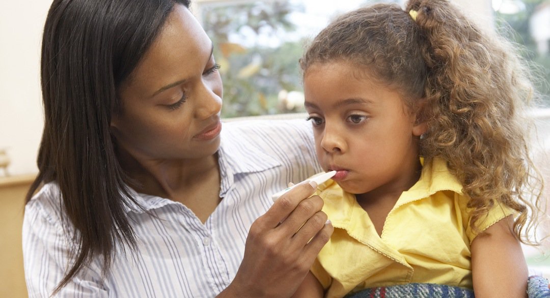 Mother taking daughter's temperature